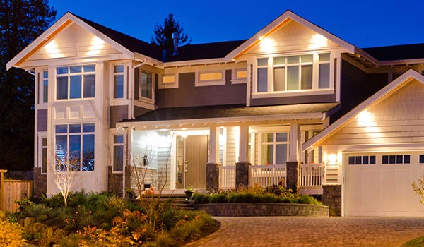 Residential home illuminated by exterior lighting at dusk